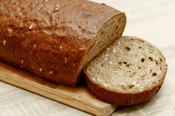 Svart bakade bröd och en skivad bit — Stockfoto