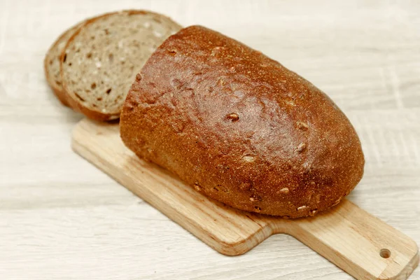 Μαύρο, ψημένο ψωμί και ένα κομμάτι κομμένο σε φέτες — Φωτογραφία Αρχείου
