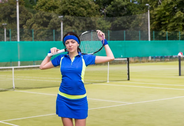 Mujer mantiene raqueta de tenis sobre sus hombros en la cancha de tenis — Foto de Stock