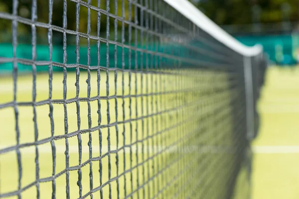 Close up van tennis netto op de achtergrond van gras rechtbanken — Stockfoto