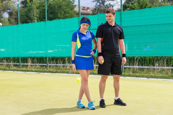 Joueuse de tennis lançant une balle de tennis près de son partenaire — Photo