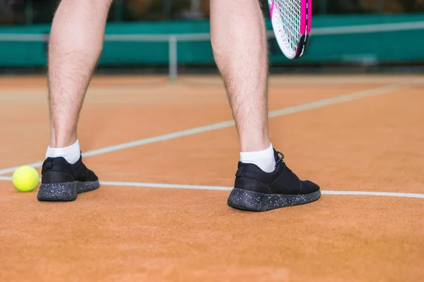 Cerrar las piernas del jugador masculino durante el juego en la cancha de barro outdoo — Foto de Stock