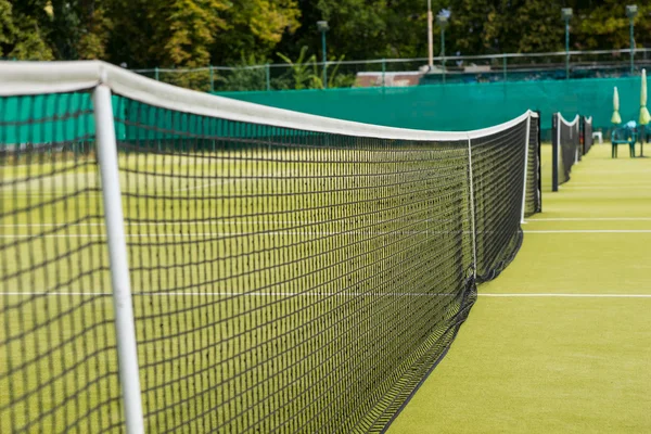 テニスの草裁判所の背景にネット — ストック写真
