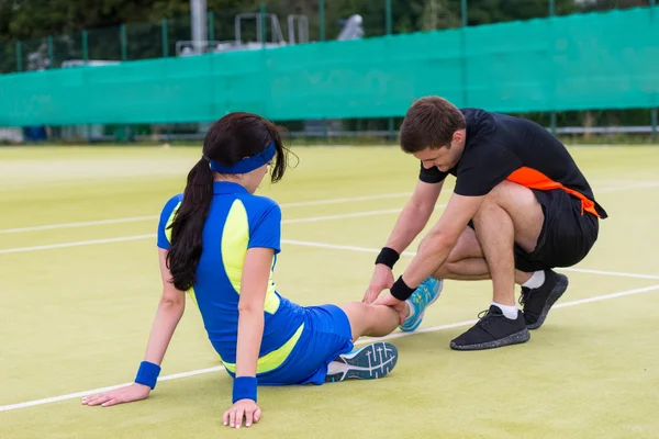 Young man doing massage to his female tennis partner — Stock Photo, Image