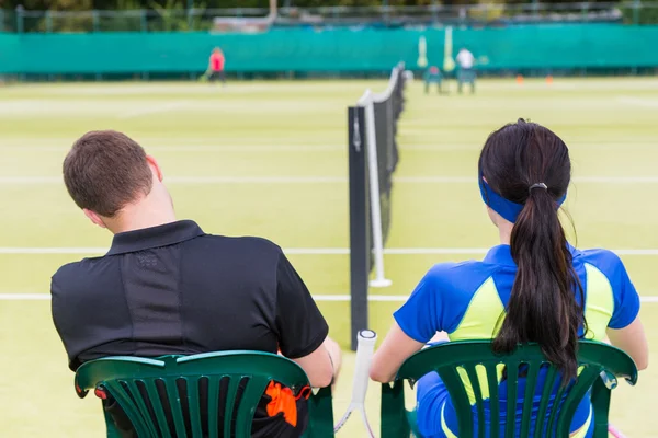Вид со спины на двух теннисисток, отдыхающих на корте — стоковое фото
