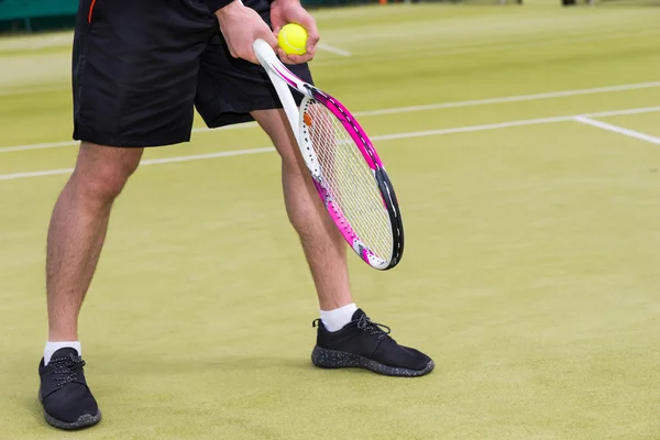 Mannelijke spelershand met tennisbal klaar om te serveren op een — Stockfoto