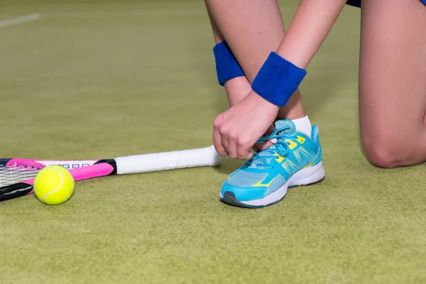 Nahaufnahme einer Tennisspielerin, die Schnürsenkel bindet — Stockfoto