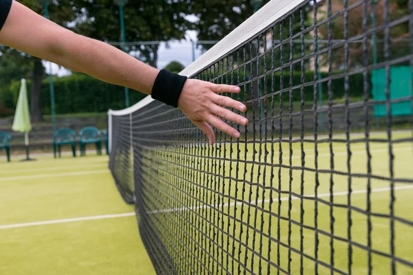 Mano masculina cerca de red de tenis — Foto de Stock