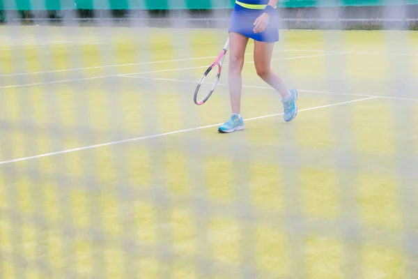 Widok przez net na nogi tenisistka 's — Zdjęcie stockowe