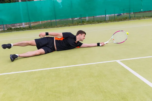 行动在比赛期间的英俊男网球选手堕落上 — 图库照片