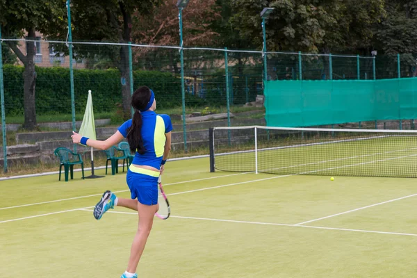 Mujer joven durante el juego en una cancha de tenis — Foto de Stock
