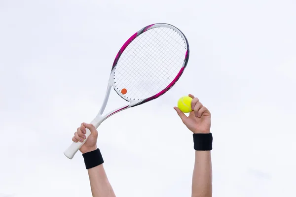 Human hands holding tennis ball and a racket on background of th — Stock Photo, Image