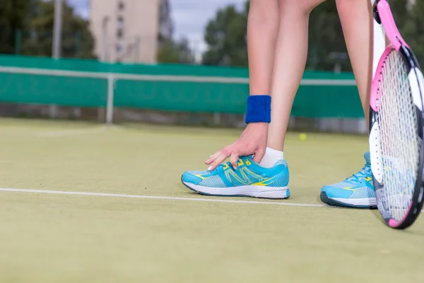 Frau bindet Schnürsenkel während Tennismatch — Stockfoto