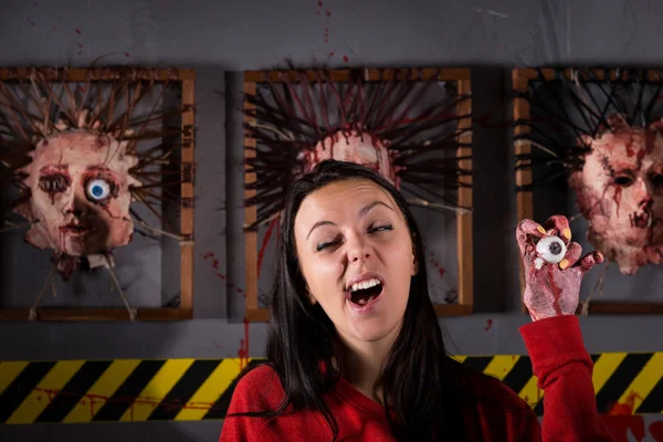Única jovem mulher estranha boceja enquanto segura o globo ocular em rugas — Fotografia de Stock