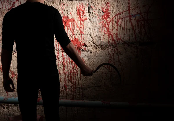 Schimmige mannelijke figuur in de buurt van bloed bevlekte muur — Stockfoto