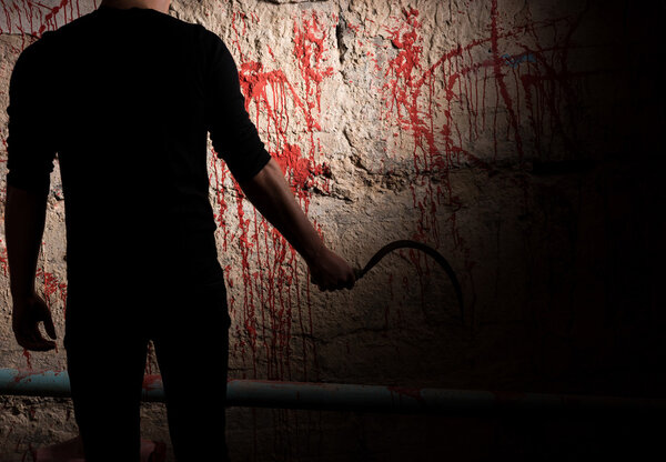 Shadowy male figure near blood stained wall