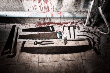 Saws, sickles, tongs and other devices on the bloody floor  in b clipart