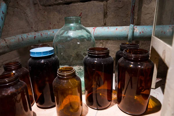 Pots et bouteilles en verre avec paroi éclaboussée de sang dans un labo teinté — Photo