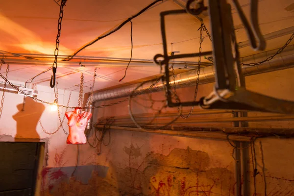 Terrible torso femenino sangriento colgando de cadenas en el sótano ingenio —  Fotos de Stock