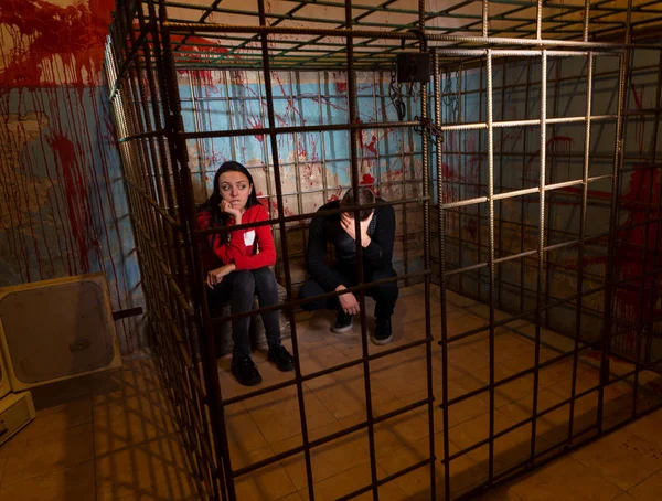 Двох наляканих жертв Хеллоуїна ув'язнено в металевій клітці — стокове фото