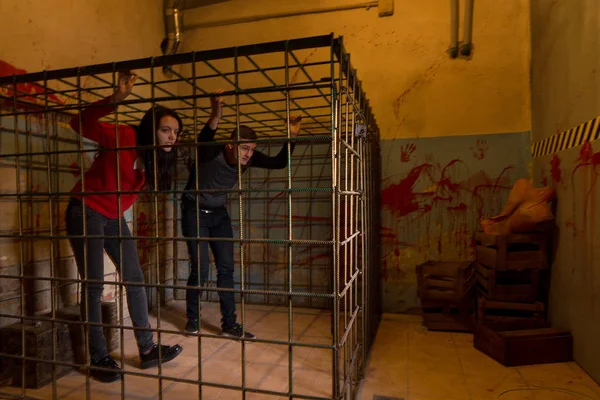 Duas jovens vítimas de Halloween presas em uma gaiola de metal tentando — Fotografia de Stock
