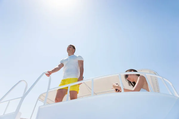 Handsome man standing on the yacht and holding on to railing — Stock Photo, Image