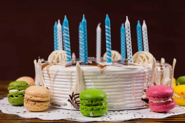 White birthday cake with lots of candles near different colored — Stock Photo, Image