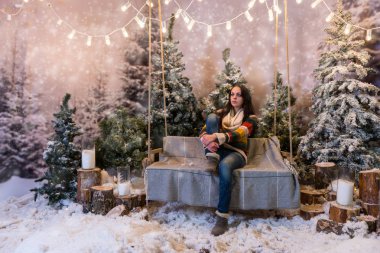 Bir tezgah veya fla yukarıda bir salıncak üzerinde oturan genç güzel kız