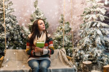 Sevimli kız bir battaniye ve h ile bir salıncak üzerinde otururken hayal