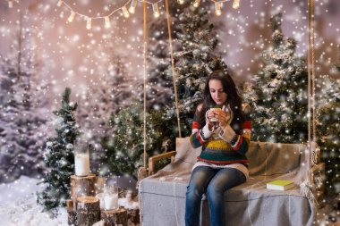 Flashlig altında bir battaniye ile bir salıncak üzerinde oturan genç kadın