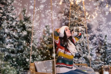 Sevimli genç kadın bir Bank ya da bir salıncak üzerinde oturan ve koyarak bir 