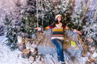 Neşeli genç kadın uzan salıncakta uzanmış kollarıyla 