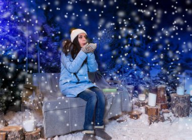 Genç kadın mavi ceket aşağı oturma o süre kar taneleri darbeler