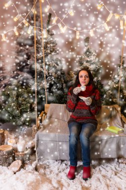 Flashli altında bir battaniye ile bir salıncak üzerinde oturan genç erkek