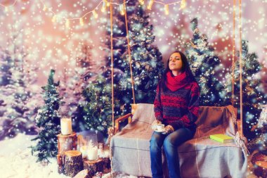 Bir battaniyenin altında ile bir salıncak üzerinde oturan genç hayal kadın