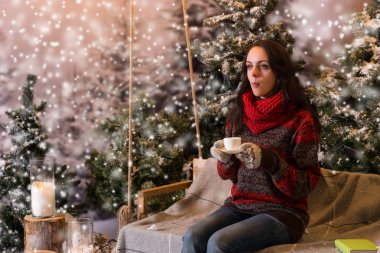Kadın bir battaniyenin altında el fenerleri ile bir salıncak üzerinde oturan bir