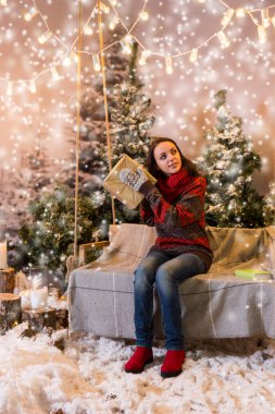 Flashlig altında bir battaniye ile bir salıncak üzerinde oturan güzel kız