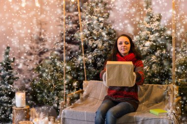 Bir battaniyenin altında el fenerleri ile bir salıncak üzerinde oturan kadın bir