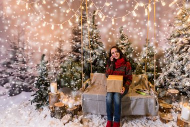 Kadın bir hediye ile bir salıncak üzerinde oturan ve üzerinde mobi konuşuyor