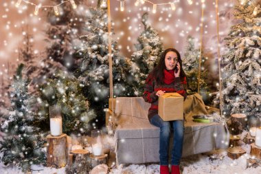 Bir hediye ile bir salıncak üzerinde oturan ve o konuşurken çekici kadın