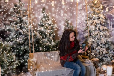 Bir salıncak üzerinde oturan ve Ladin bir fotoğraf çekici çekici kadın