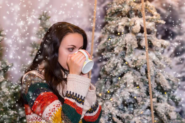 Hermosa mujer bebiendo bebida caliente de una taza en una nieve cubierta — Foto de Stock