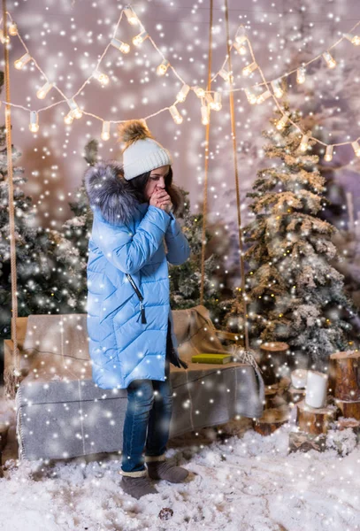 Cute žena v modrém péřová bunda oteplování rukou a stojící poblíž s — Stock fotografie