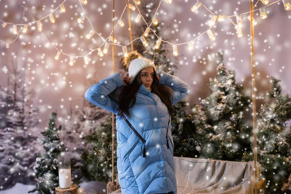 Mavi bir salıncak duran ve puttin ceket aşağı sevimli erkek