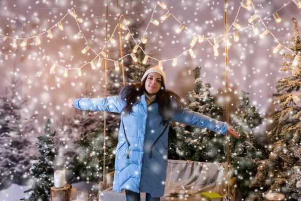 Girl in blue down jacket rejoicing because of snowing standing n — Stock Photo, Image