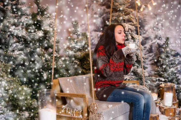 Jonge vrouw zitten op een schommel met een deken onder het flashlig — Stockfoto