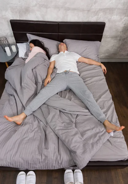 Ung man sover i fritt fall position med hustrun ockuperade — Stockfoto