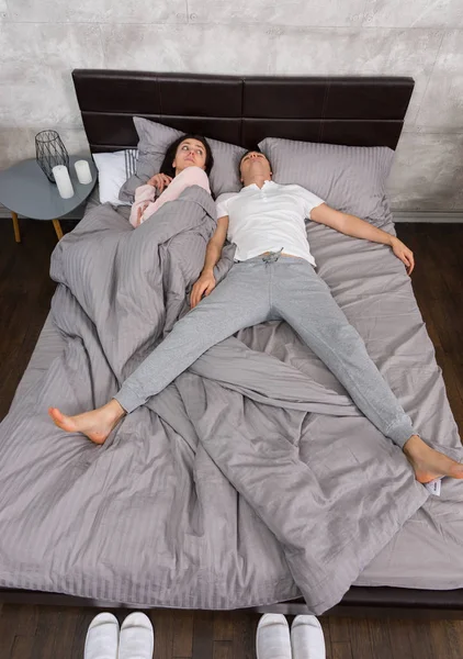 Jovem do sexo masculino dormindo em posição de queda livre com sua esposa ocupada — Fotografia de Stock