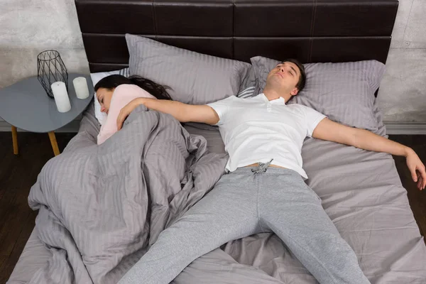 Joven macho durmiendo en caída libre posición con su novia oc — Foto de Stock