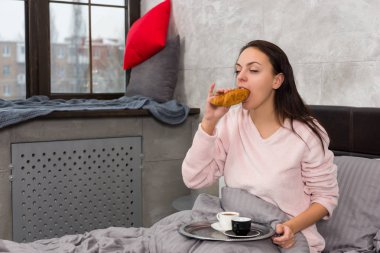 Genç kadın sadece kruvasan yemek uyandım ve onun breakfa sahip